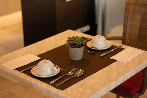 una mesa con dos platos y una maceta en ella en Hotel Villa Marcilla, en Marcilla