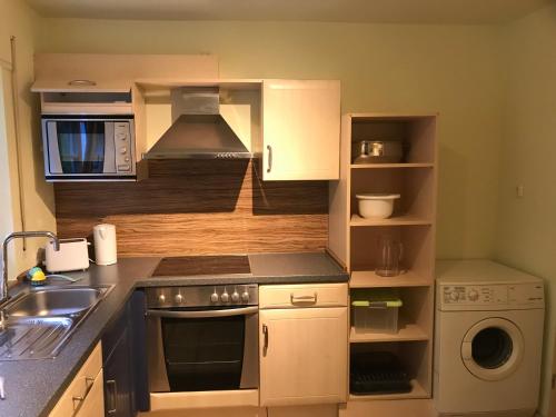 a kitchen with a sink and a stove top oven at Ferienwohnung Hesselbach in Oberkirch