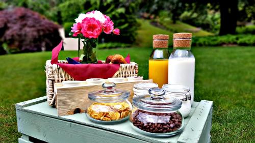 un tavolo da picnic con barattoli di cibo e bottiglie di latte di Domus Plinii 1792 Suites a Faggeto Lario