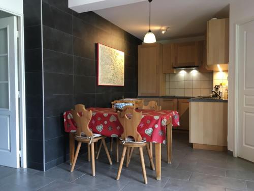 a kitchen with a table with a red table cloth at Chalet de l'Orceyrette, idéal pour un couple ou famille avec 2 enfants in Briançon