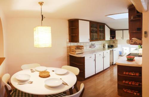 ピランにあるApartment L&Mの白いテーブルと白い椅子のあるキッチン