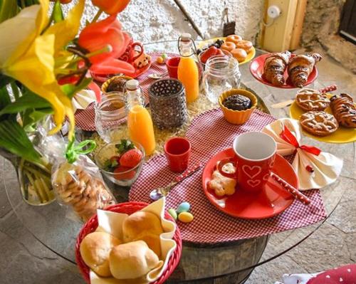 a table topped with plates of food and orange juice at Il Roccolino in Valsecca