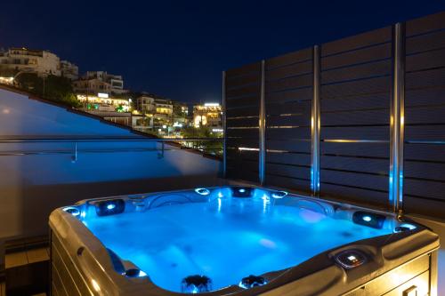 a jacuzzi tub on a balcony at night at Angels Suites in Plataniás