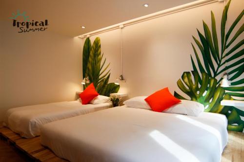 two beds in a room with plants on the wall at Tropical Summer Hostel in Bangkok