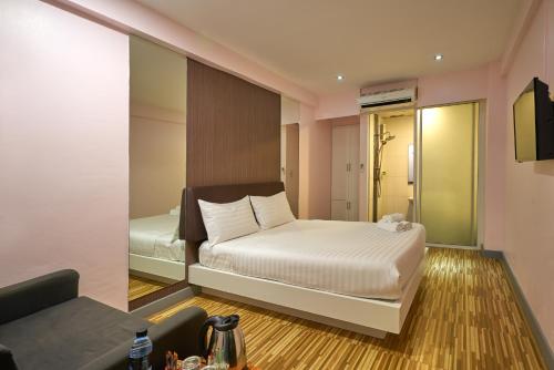 a small bedroom with a bed and a mirror at Sweetloft Hotel Don Muang in Bangkok