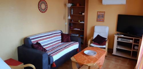 un salon avec un canapé et une télévision dans l'établissement paesolu, à Porticcio