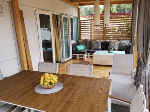 a wooden table with a bowl of bananas on it at Mobile Home BelDesiderio Soline in Biograd na Moru