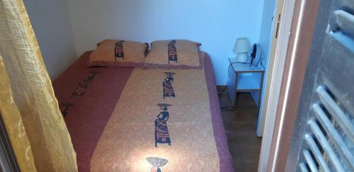 Ce lit se trouve dans une petite chambre dotée d'un couvre-lit avec un sèche-cheveux. dans l'établissement paesolu, à Porticcio