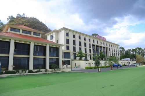 a building with a green field in front of it at Haile Resort-Gondar in Gonder