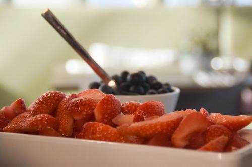 a bowl of strawberries and blueberries on a plate at Fruitpark Hotel & Spa in Ochten