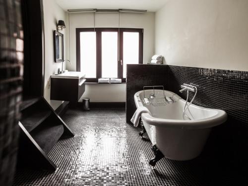 a black and white bathroom with a tub and a sink at B in Antwerp in Antwerp