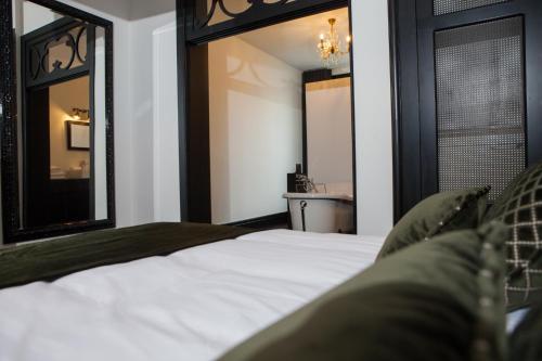 a bedroom with a bed and two mirrors at B in Antwerp in Antwerp
