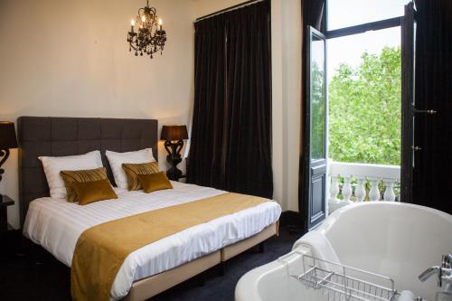 a bedroom with a large bed and a bath tub at B in Antwerp in Antwerp