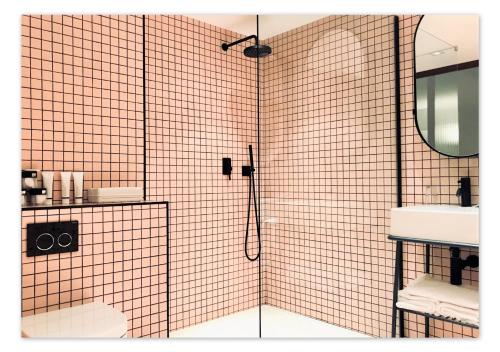 Un baño con ducha con lavabo y espejo. en Hôtel Le Versailles, en Villefranche-sur-Mer