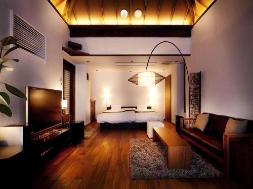 a bedroom with a bed and a living room with a couch at Hanare Matsushimakaku in Aizuwakamatsu