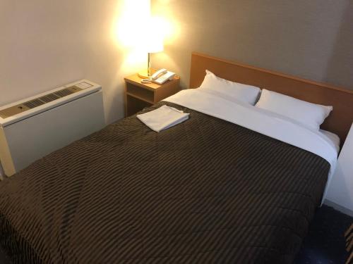 a hotel room with a large bed with a lamp on it at Chitose Airport Hotel in Chitose
