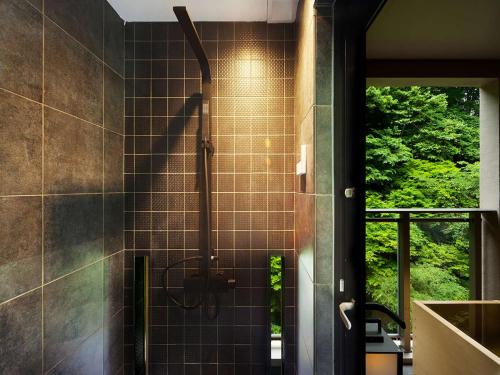 baño con cabina de ducha y ventana en Hanare Matsushimakaku, en Aizuwakamatsu