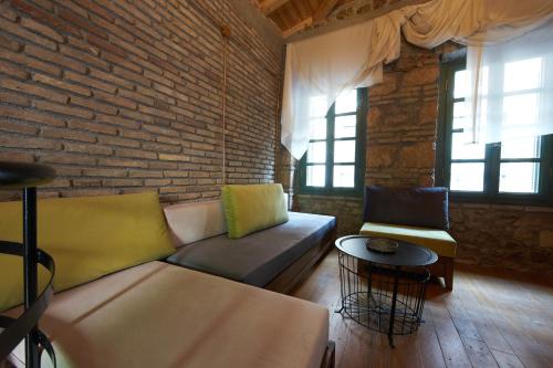 a living room with a couch and a brick wall at Athenian Residences in Athens