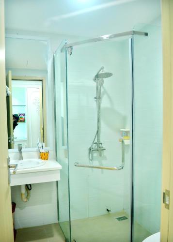 a bathroom with a glass shower and a sink at Phuong Hoang Hotel 2 in Sầm Sơn
