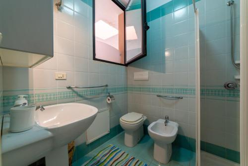 bagno con lavandino, servizi igienici e specchio di Appartamento Parco dei Pini a Torre dell'Orso