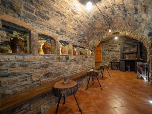 a room with a stone wall with tables and a fireplace at Apartamento Casa Dueso in El Pueyo de Araguás