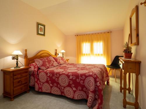 a bedroom with a bed and a desk and a window at Apartamento Casa Dueso in El Pueyo de Araguás