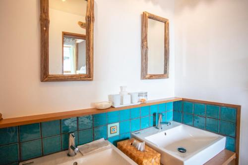 a bathroom with a sink and two mirrors at Katsuo Guest House in Kochi