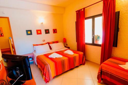 a hotel room with two beds and a window at Villa Sunset B&B/Apartments in Fontane Bianche