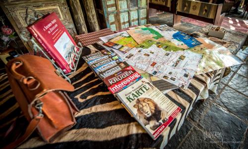 a table with a book and magazines on it at Rio Dos Elefantes River Camp in Hoedspruit
