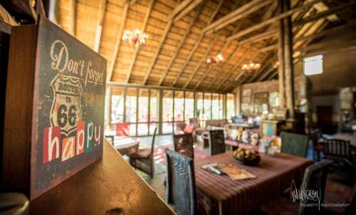a restaurant with a table and a sign on a wall at Rio Dos Elefantes River Camp in Hoedspruit
