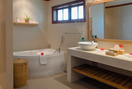 La salle de bains est pourvue d'une baignoire, d'un lavabo et de toilettes. dans l'établissement Hotel L'Archipel, à Baie Sainte-Anne