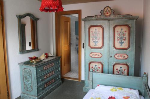 a bedroom with a bed and a dresser and a mirror at Hotel Schäfflerhof in Bischofsmais