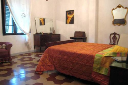 1 dormitorio con 1 cama, 1 silla y 1 ventana en a casa di antonio, en Lucca