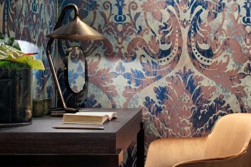 a desk with a lamp and books on a wall at Hotel American-Dinesen in Venice
