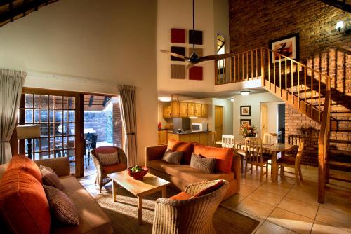 a living room with a couch and a table at Kruger Park Lodge in Hazyview