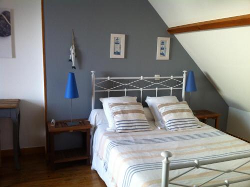 
a bedroom with two beds and a lamp at Les Transats Chambre et appartements vue mer in Barfleur
