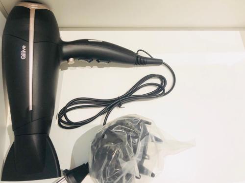 a black hair dryer sitting on top of a shelf at L'Atelier in Beauvais