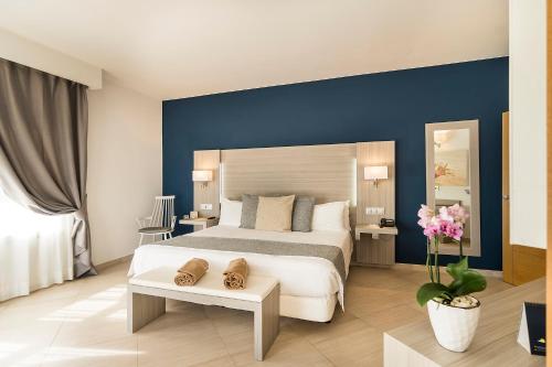 a bedroom with a large bed with a blue wall at Royal Palm Resort & Spa - Adults Only in Playa Jandia