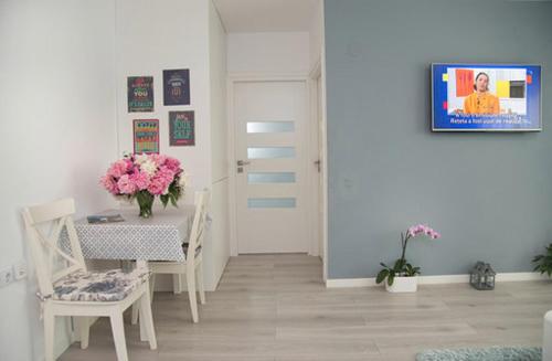 a white room with a table and chairs and a door at Adma Apartments in Sibiu