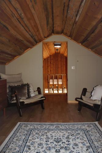 a living room with two couches and a wooden ceiling at Backens Fjällboende in Tännäs