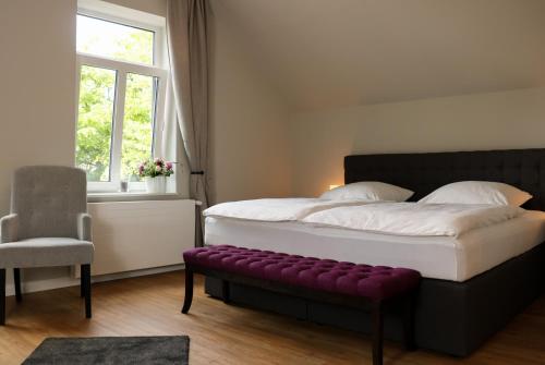 Schlafzimmer mit einem großen Bett und einer lila Bank in der Unterkunft Stadt Apartments Burg Fehmarn in Burg auf Fehmarn