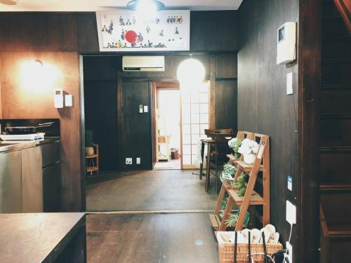 a kitchen with wooden walls and a hallway with a table at Kyoto Inari Guest House Tonoya villa in Kyoto