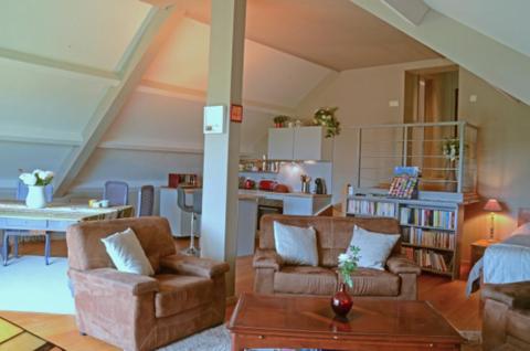a living room with two chairs and a table at Un brin de Paradis "appartement de 100 m²" in Harzé