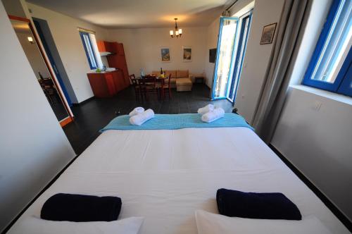 a bedroom with a large white bed with towels on it at Fanaraki Beach Studios in Mirina