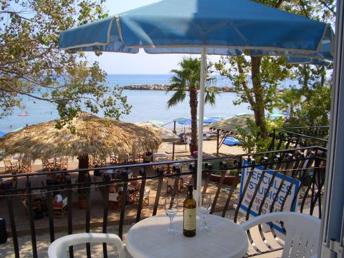 a table with a bottle of wine on a balcony with a beach at Hercules Sea Front Studios in Katelios