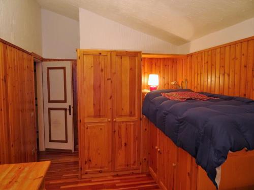 a bedroom with wooden walls and a bed in it at Appartamento La Primula in Madesimo