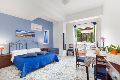 a bedroom with a blue bed and a dining room at Sorrento Marida Rooms in Sorrento