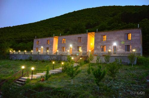 a large building with lights in a yard at night at Yeghevnut Hotel in Goris