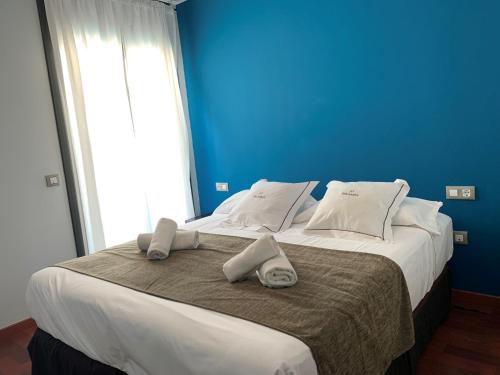 Un dormitorio azul con una cama grande con toallas. en Palamós Apartamentos, en Palamós