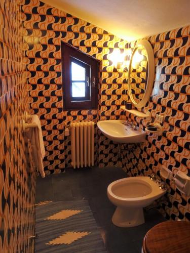 a bathroom with a sink and a toilet and a mirror at Appartamento La Primula in Madesimo